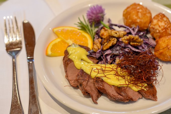 Wildentenbrust sous vide gegart, auf Orangensabayon mit Mandelkrusteln und Rotkohlsalat 